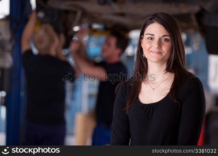 A happy female auto repair customer looking at the camera with a smile