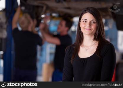 A happy female auto repair customer looking at the camera with a smile