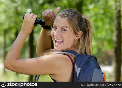 a happy female birdwatcher shows thumbs up