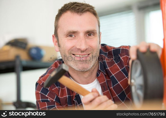 a happy man hammer a nail