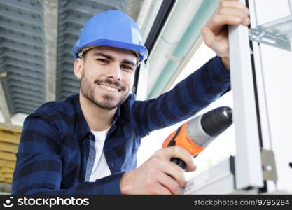 a happy man holds a drill