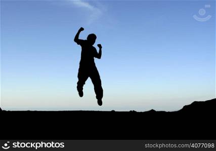A happy man jumping in the air, in silhouette