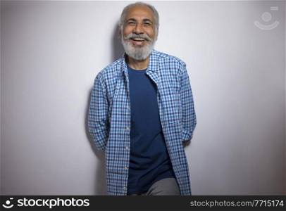 A HAPPY OLD MAN CHEERFULLY POSING IN FRONT OF CAMERA