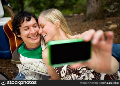 A happy playful couple on a picnic taking a self portrait