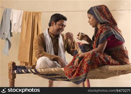 A HAPPY RURAL COUPLE SITTING AND DRINKING TEA TOGETHER