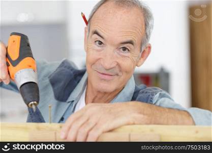 a happy senior carpenter at work