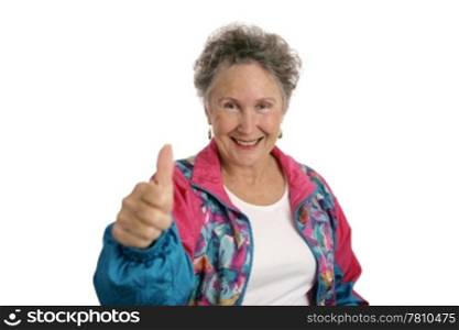 A happy senior woman in a track suit giving a thumbsup sign. Isolated on white.
