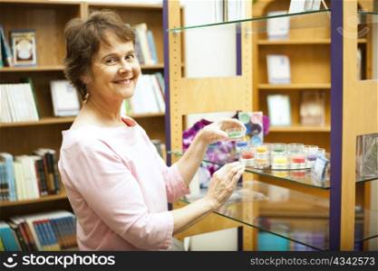 A happy shop owner arranging a display on the shelf.
