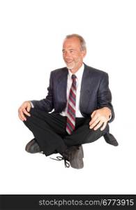 A happy smiling middle age businessman in a suit, sitting on the floorisolated for white background.