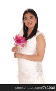 A happy smiling young bride standing in her white wedding dress and long black hair holding a lily in her hand, isolated for white background