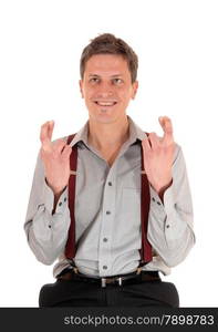 A happy smiling young man in a grey shirt, holding up his hands and crossing his fingers, Isolated for white background.