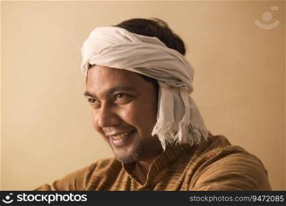 A HAPPY TURBANED MAN LOOKING ABOVE AND SMILING