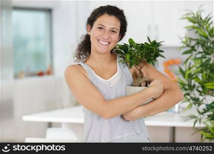 a happy woman hugging plant