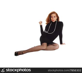 A happy woman in a black dress and long brunette hair sitting onthe floor, isolated for white background.