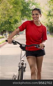 A HAPPY WOMAN STANDING IN FRONT OF CAMERA WITH BICYCLE