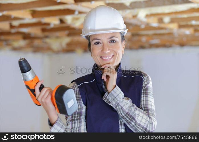 a happy woman using a drill