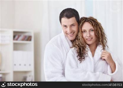 A happy young couple in dressing gowns at home