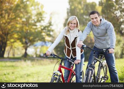 A happy young couple on bicycles in the park
