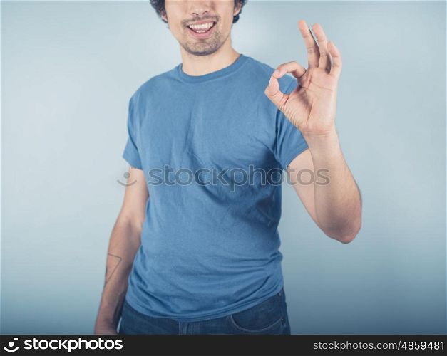 A happy young man is displaying an ok sign with his fingers