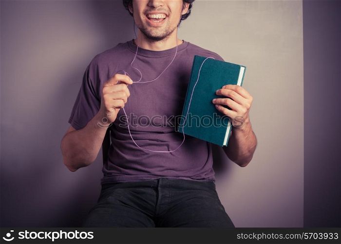 A happy young man is listening to an audio book