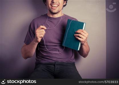 A happy young man is listening to an audio book