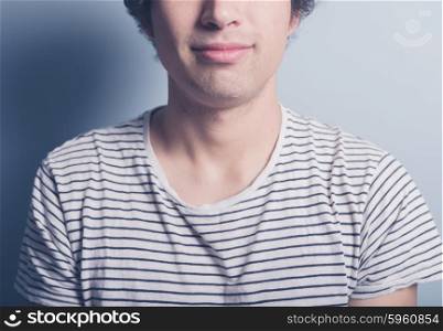 A happy young man is wearing a black and white stripey t-shirt