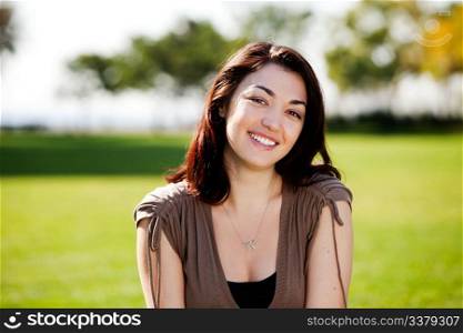 A happy young student outside in a park