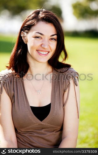 A happy young student outside in a park