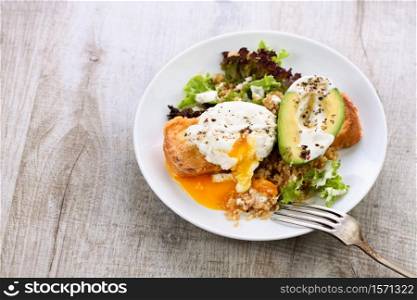 A healthy and balanced breakfast plate.Benedict&rsquo;s egg spreads on a toasted toast with half an avocado, quinoa and lettuce, seasoned spices and yogurt dressing. Enjoy the most important meal of the day