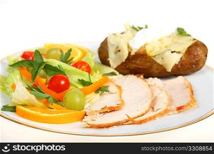 A healthy turkey salad dinner, with a baked potato topped with mayonnaise, against a white background. A less fattening option for festive occasions