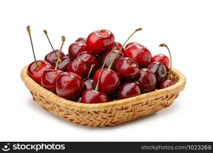 A heap of red fresh and natural cherries in a rattan basket