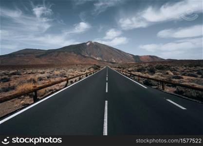 A high angle shot of a highway surrounded by hills under the cloudy sky. High angle shot of a highway surrounded by hills under the cloudy sky