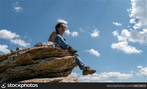 a hiker woman sitting on a rock