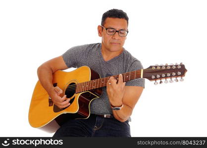 A Hispanic handsome man sitting on a chair and playing his guitar,isolated for white background.