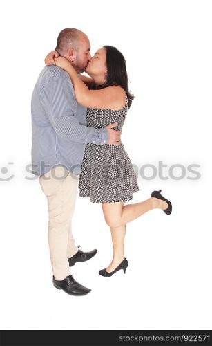A Hispanic middle age couple standing in the studio and kissing each other, strong love, isolated for white background