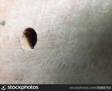 a hole in a wooden board close up macro selective blur