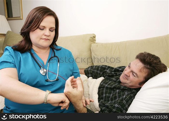 A home health nurse taking the patient&rsquo;s pulse.