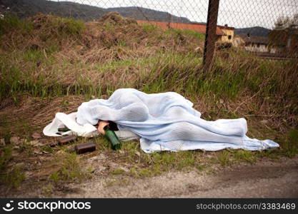 A homeless drunk person sleeping in the ditch