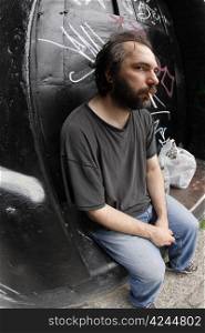 A homeless man on the city streets, filled with anxiety and hopelessness. Shot with fish-eye lens.