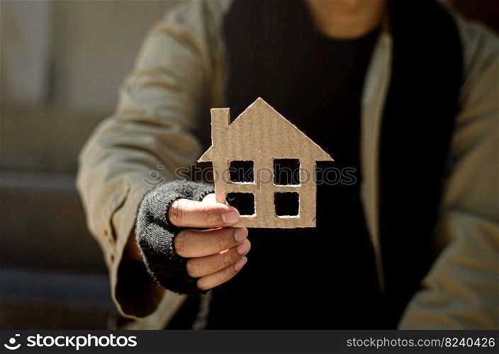 A homeless man who is discouraged, desperate, erring from life. homeless A homeless beggar handed a picture of a paper house for help with donations.