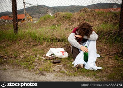 A homeless person sleeping in the ditch