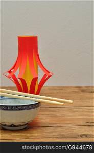 A homemade lantern display with a pair of chopsticks and a bowl