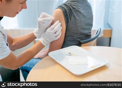 A horizontal view of a female doctor disinfecting a female patient"s arm after a vaccination
