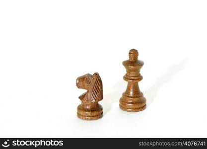 A horse and a king chess pieces on isolated white