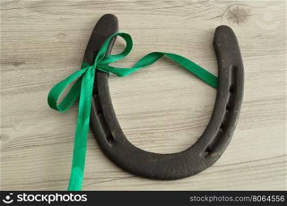 A horse shoe tied with a green ribbon for St. Patrick's day