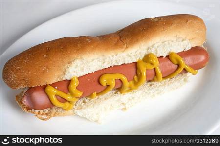 A hot dog frankfurter sausage in a bun with mustard