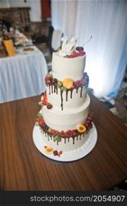 A huge cake decorated with fruits and berries for the wedding.. A four-story wedding cake 2776.