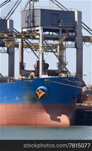 A huge crane unloading ore from a bulk carrier