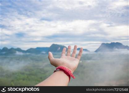 a human hands and foggy view mountain