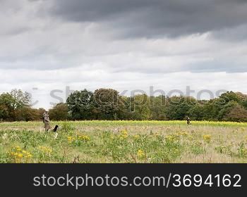 A hunter and his dogs in a field